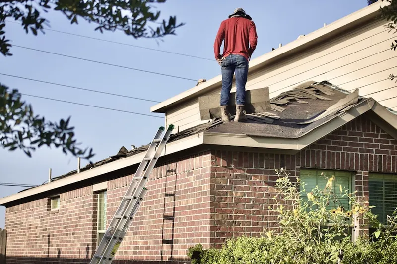 Professional roofer working on a residential roof in Fowler